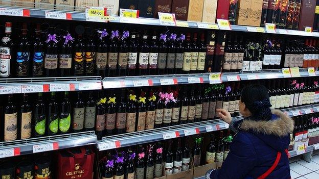 A woman looks at wine in a supermarket in Hubei, China (Feb 2014)