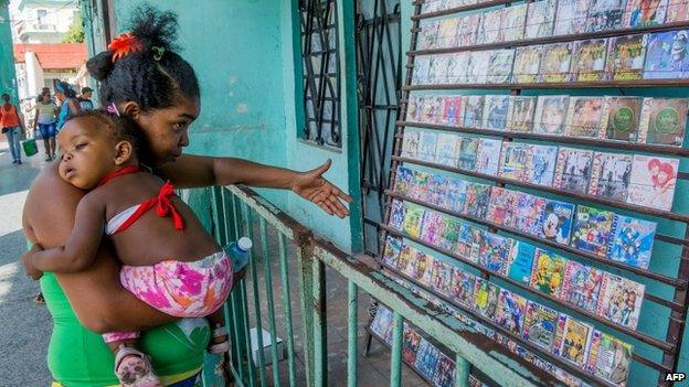 A woman looks at compact discs on sale at a private business stall in Havana (25 November 2014)