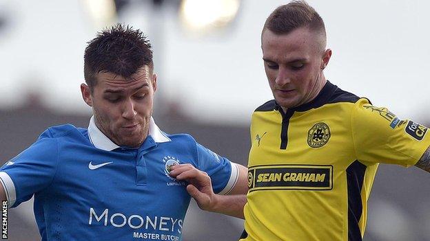 Linfield's Stephen Lowry in action against Jude Winchester of Cliftonville