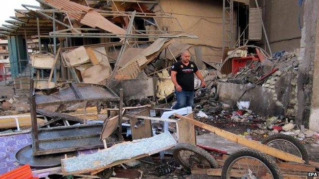 Iraqis inspect the scene of a car bomb attack at Karada district in central Baghdad, Iraq, 18 October 2014