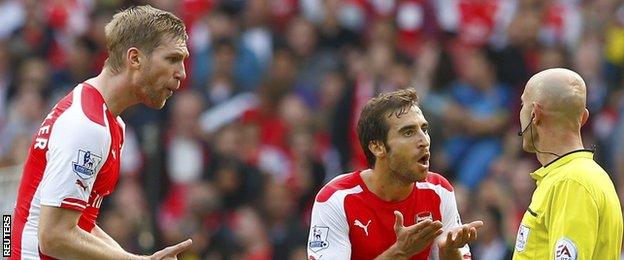 Arsenal's Per Mertesacker and Mathieu Flamini argue with the referee