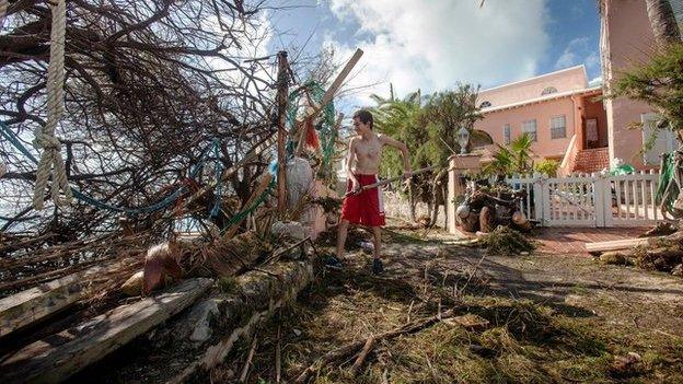 Stefano Ausenda shovels debris away from his driveway after Hurricane Gonzalo passed through in Sandys Parish, western Bermuda, October 18, 2014