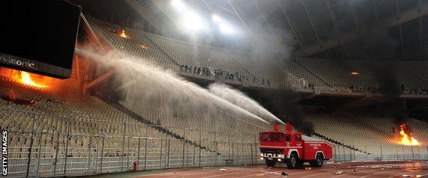 March 2012: A fire engine sprays water on fires set in the stadium during clashes between riot police and Panathinaikos supporters during the Athens derby