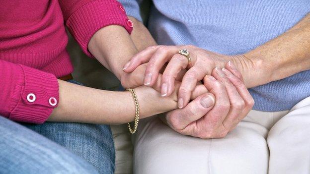 Elderly woman being comforted by a carer