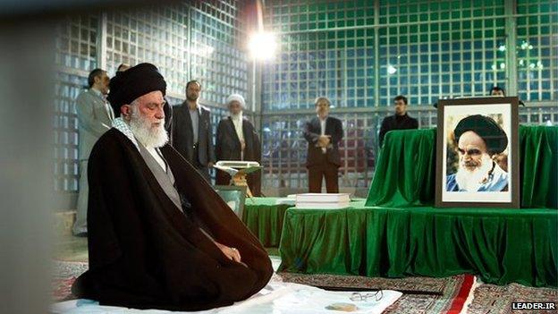 Ayatollah Khamenei (left) next to portrait of Ayatollah Khomeini