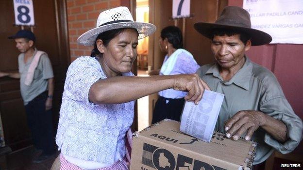 A woman deposits her ballot during the presidential election in Cochabamba on 12 October, 2014