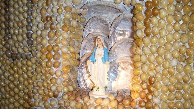 Statue and periwinkle shells inside Le Galloudec shell shrine at Fort Hommet, Guernsey