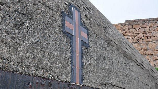 Cross on the outside of the WW2 bunker housing Le Galloudec shell shrine at Fort Hommet, Guernsey