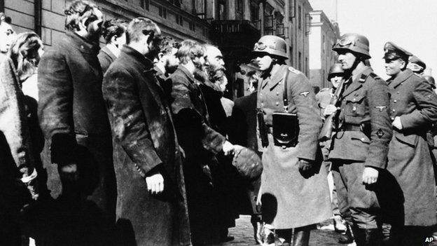 Nazi officers talk to people living in a ghetto in Warsaw, Poland, in 1943