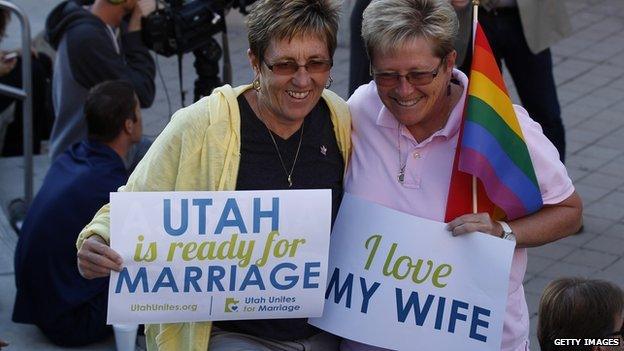 Two women hold signs promoting gay marriage rights outside a Utah courthouse.