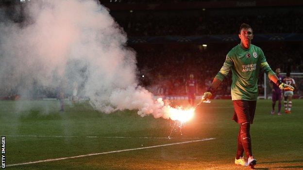 Fernando Muslera of Galatasaray clears a flare