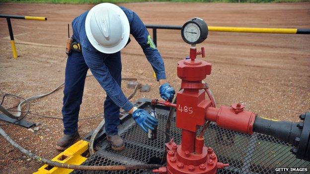 An engineer takes a sample of heavy crude oil in Colombia, on August 27, 2013