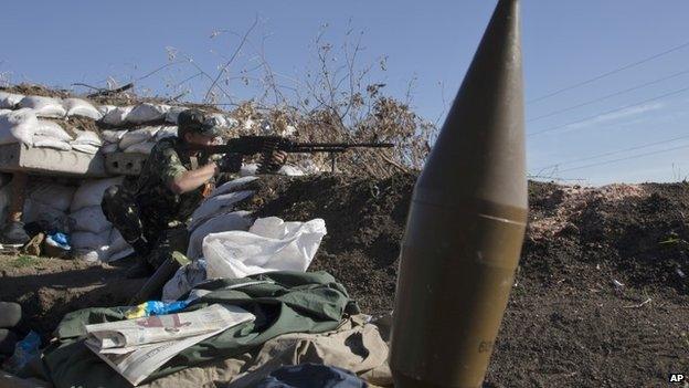 A pro-Russian rebel aims his weapon at a check-point in Donetsk