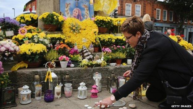 Flowers and messages of condolence besides the clock tower in Hanwell