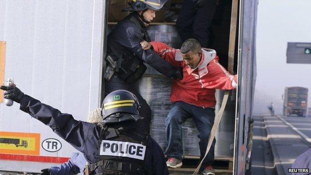 French riot policemen force out migrants in Calais, France on 22 October 2014