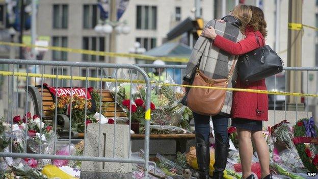 People pay their respects at the National War Memorial in Ottawa on 23 October 2014