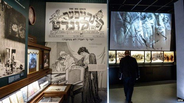 View of the The Street gallery showing display cases, posters and a black and white film