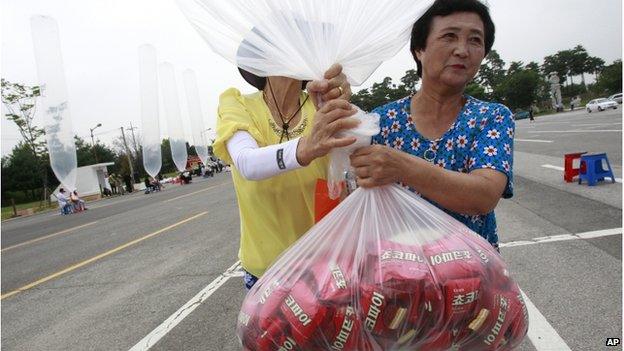 North Korean defectors carry to release a balloon to let it fly to the North, carrying chocolate pies and cookies during a rally against the North's recent threat at the Imjingak Pavilion near the border village of Panmunjom (DMZ) that separates the two Koreas since the Korean War, in Paju, South Korea, Wednesday, 30 July 2014.