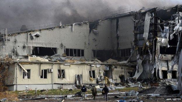 Pro-Russian separatist fighters and journalists run for cover during shelling of the Donetsk's Sergey Prokofiev international airport on 16 October 2014