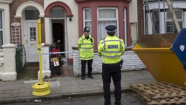 Police officers outside a house