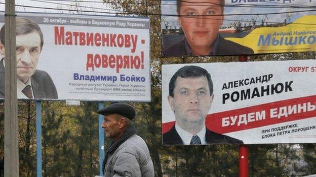 A man walks past election posters in Kiev, Ukraine on 23 October 2014