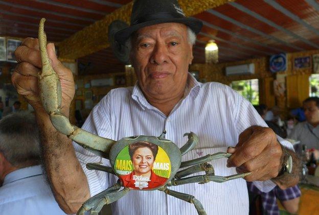 Restaurant owner Luiz da Gia with his famous pet crab displaying a Dilma Rousseff sticker