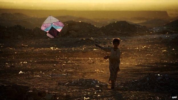 An Afghan child plays with a kite on the outskirts of Herat, Afghanistan, 20 October 2014