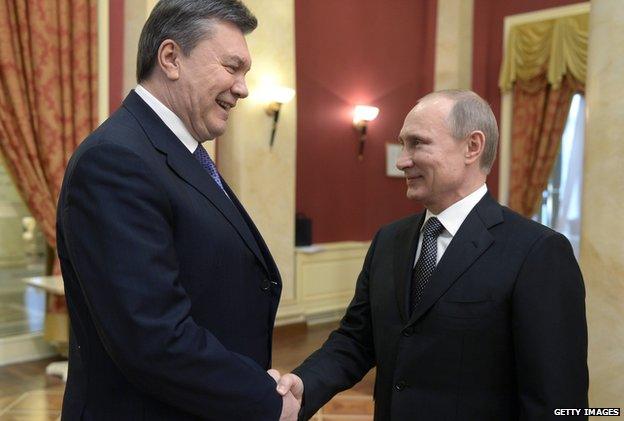 Russia's President Vladimir Putin (right) shakes hands with Viktor Yanukovych in February 2014