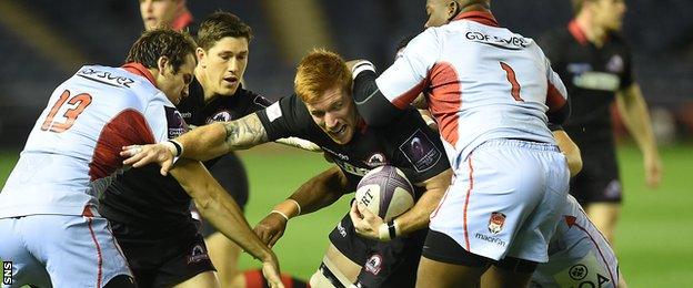 Roddy Grant manages to hold on to the ball under pressure from Lyon