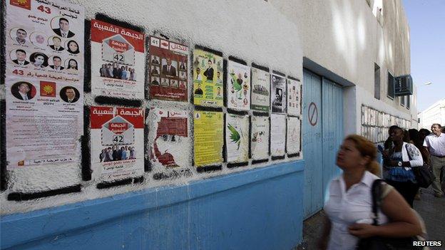 People look at parliamentary election posters in Tunis October 22, 2014. Tunisians go to the polls on October 26 for their second free parliamentary election.