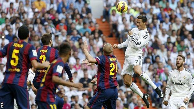 Real Madrid's Cristiano Ronaldo rises above the Barcelona defence