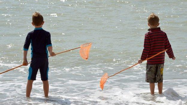 Boys standing in the sea.