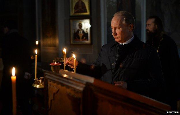 Russia President Putin lights a candle at a memorial service in a church in the village Lermontovo near the city of Penza, the birthplace of the Russian poet Mikhail Lermontov, on October 15, 2014