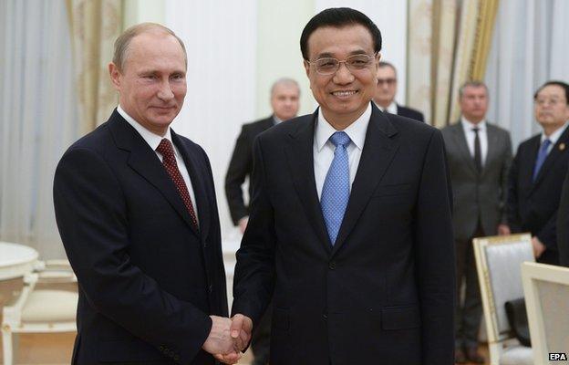 Russia"s President Vladimir Putin (L) shakes hands with China"s Premier Li Keqiang during a meeting at the Kremlin in Moscow, October 14, 2014