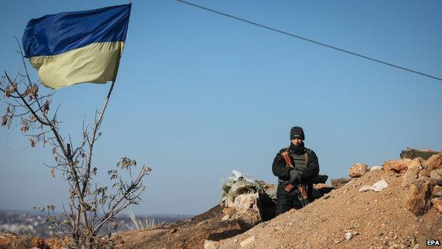 A Ukrainian serviceman stands guard at a military camp near the eastern Ukrainian town Kramatorsk, near of Sloviansk, 26 October 2014.