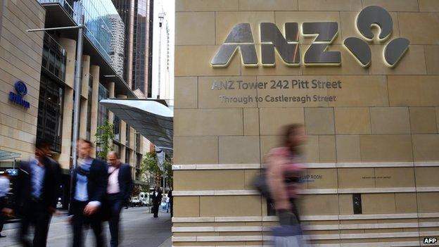 Pedestrians walk past the entrance to the Australia and New Zealand Banking Group (ANZ) building