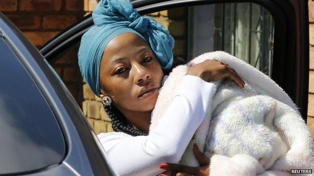 Kelly Khumalo arrives holding a baby at her home in the township of Vosloorus, South Africa on 27 October 2014