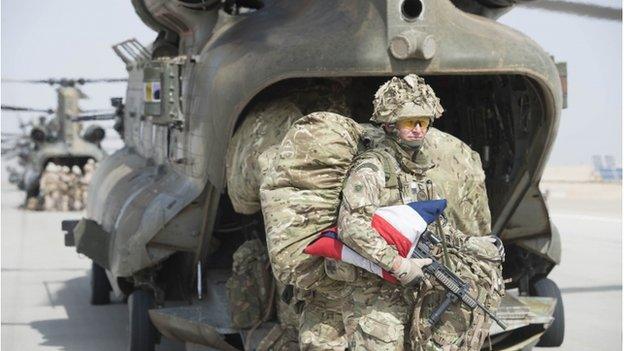 A British serviceman holding a union jack