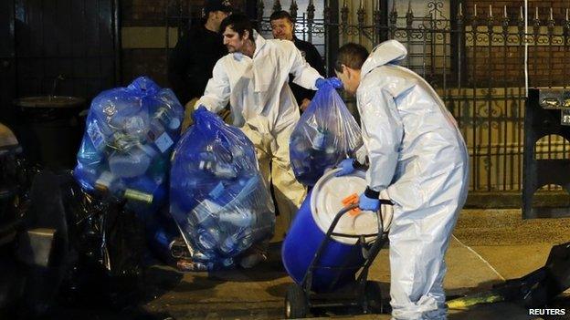 Members of a cleaning crew with "Bio Recovery Corporation" wearing personal protective equipment (PPE) push a barrel to be loaded in a truck of Centers for Disease Control and Prevention (CDC) after cleaning the apartment where Dr. Craig Spencer lives in New York October 24, 2014.