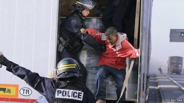 French police remove migrants from a lorry at the Calais ferry terminal