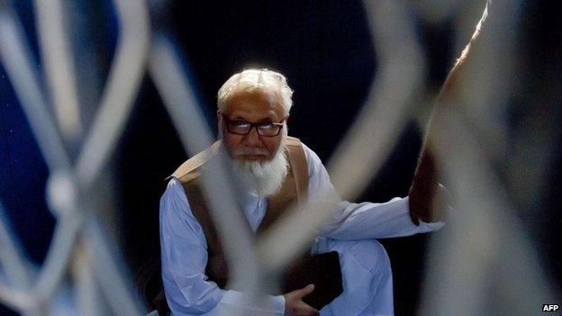 Bangladeshi Jamaat-e-Islami party leader Motiur Rahman Nizami sits inside a van as he is taken to a prison after being sentenced in Dhaka, 29 October 2014