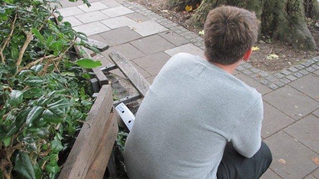 Matt sitting on a bench facing away