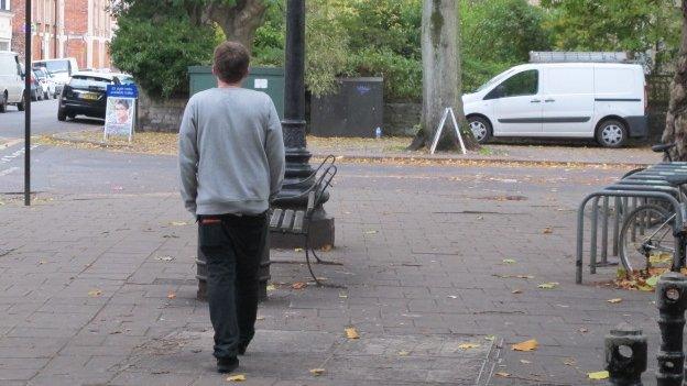 Matt walking away down a street