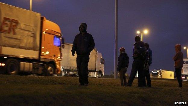 Migrants standing by lorries at ferry port in Calais