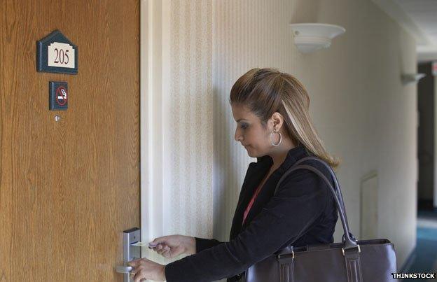 Woman opens hotel door with key card