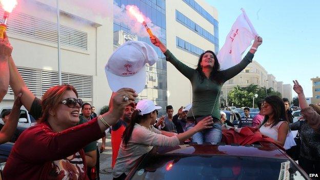 Supporters of Beji Caid Essebsi, head of the Tunisian movement "Nidaa Tounes" celebrate after early indications showed the secularist movement in first place in the legislative election in Tunis