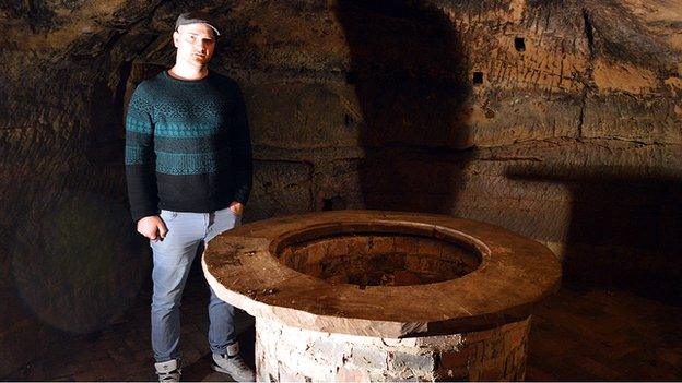 Man standing next to well