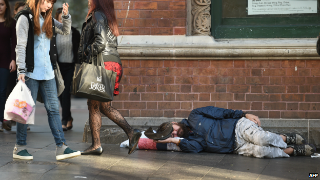 A homeless man holds out his cap for money in Sydney's Central Business District - 10 July 2014