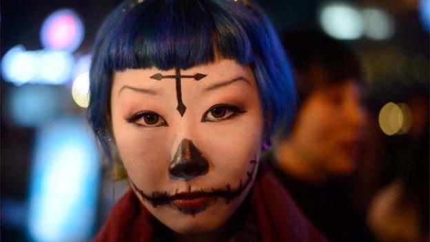 A woman with make-up poses while revellers celebrate Halloween in Beijing on October 31, 2013