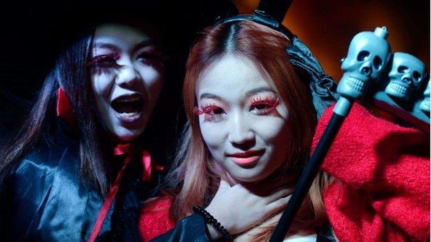 Women in costumes pose while revellers celebrate Halloween in Beijing on October 31, 2013